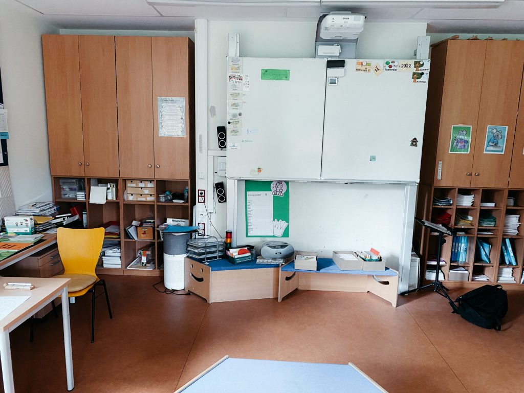 Klassenzimmer, eine helle Wand mit diversen Unterrichtsmaterialien