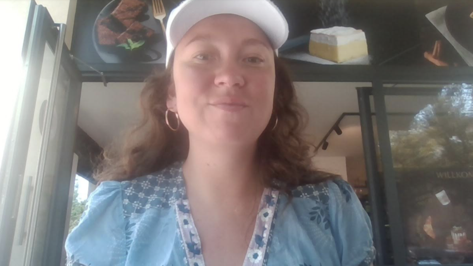 Selfie von einer jungen Frau mit hellblauen Shirt und weisser Kappe