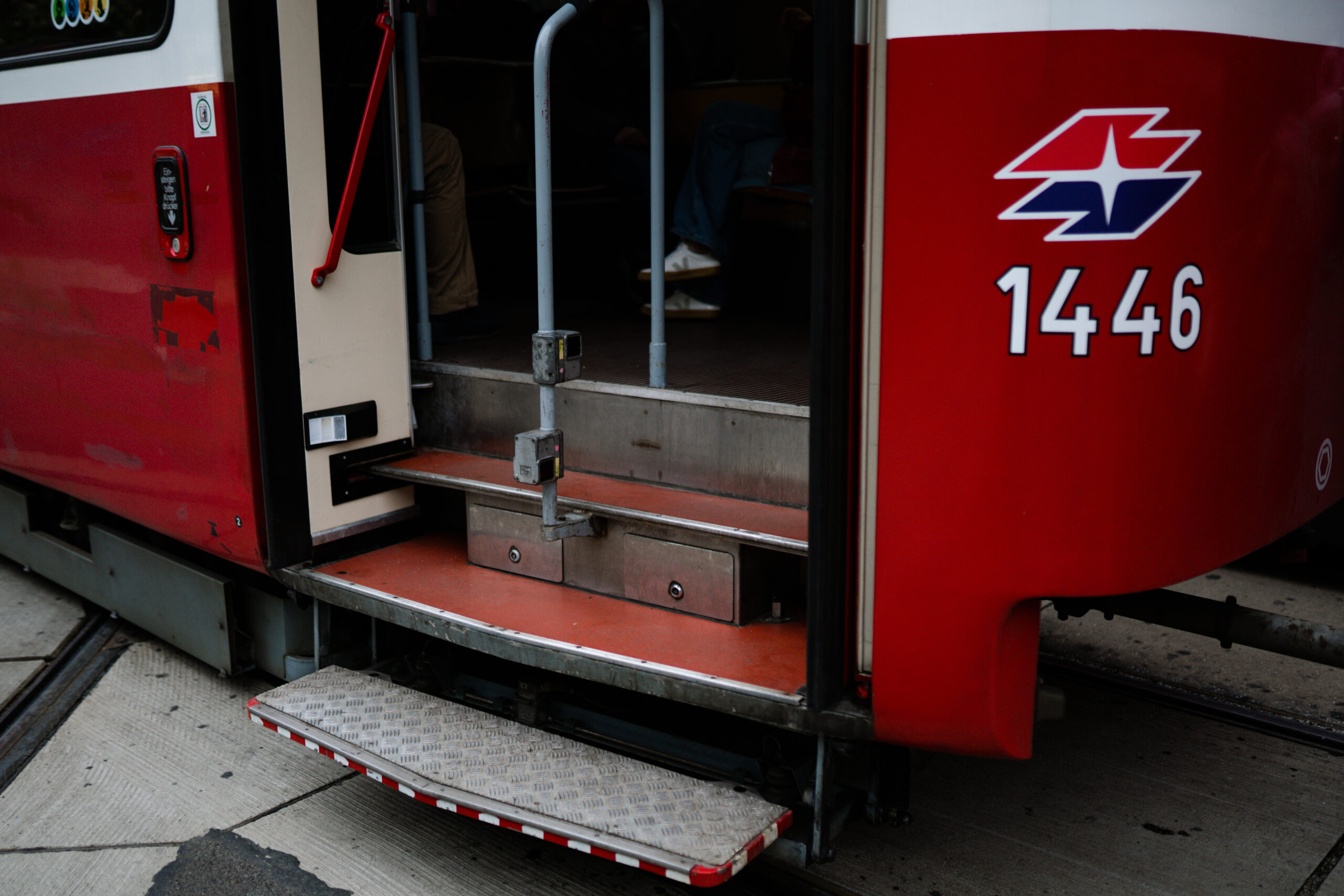 Einstieg einer alten Strassenbahn in Wien. Hochflurige Treppenstufen