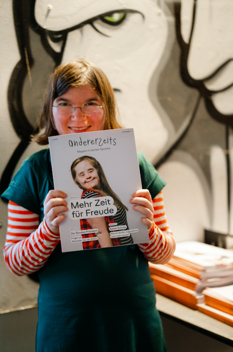 Autorin Luise hält die erste Ausgabe unseres gedruckten Magazins in die Kamera. Auf dem Cover ist Redakteurin Hanna Gugler