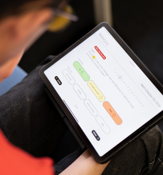 Eine Person hält ein Tablet in der Hand. Das Display zeigt Informationen zu der Nationalrats-Wahl 2024 an.