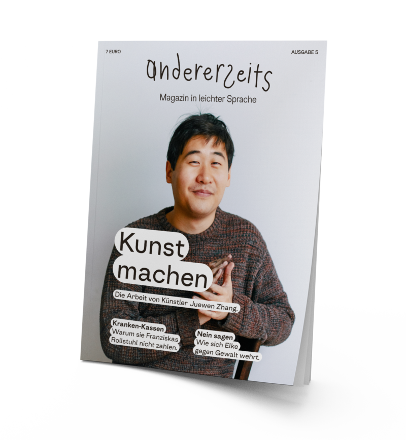 Auf dem Magazin ist der Künstler Juewen Zhang. Er hat schwarze Haare,trägt einen Strickpulli und lächelt in die Kamera. Sein Hände sind voller Kohle.