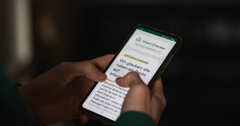 Ein Mensch tippt auf einem Smartphone, auf dem der Wahlchecker geöffnet ist