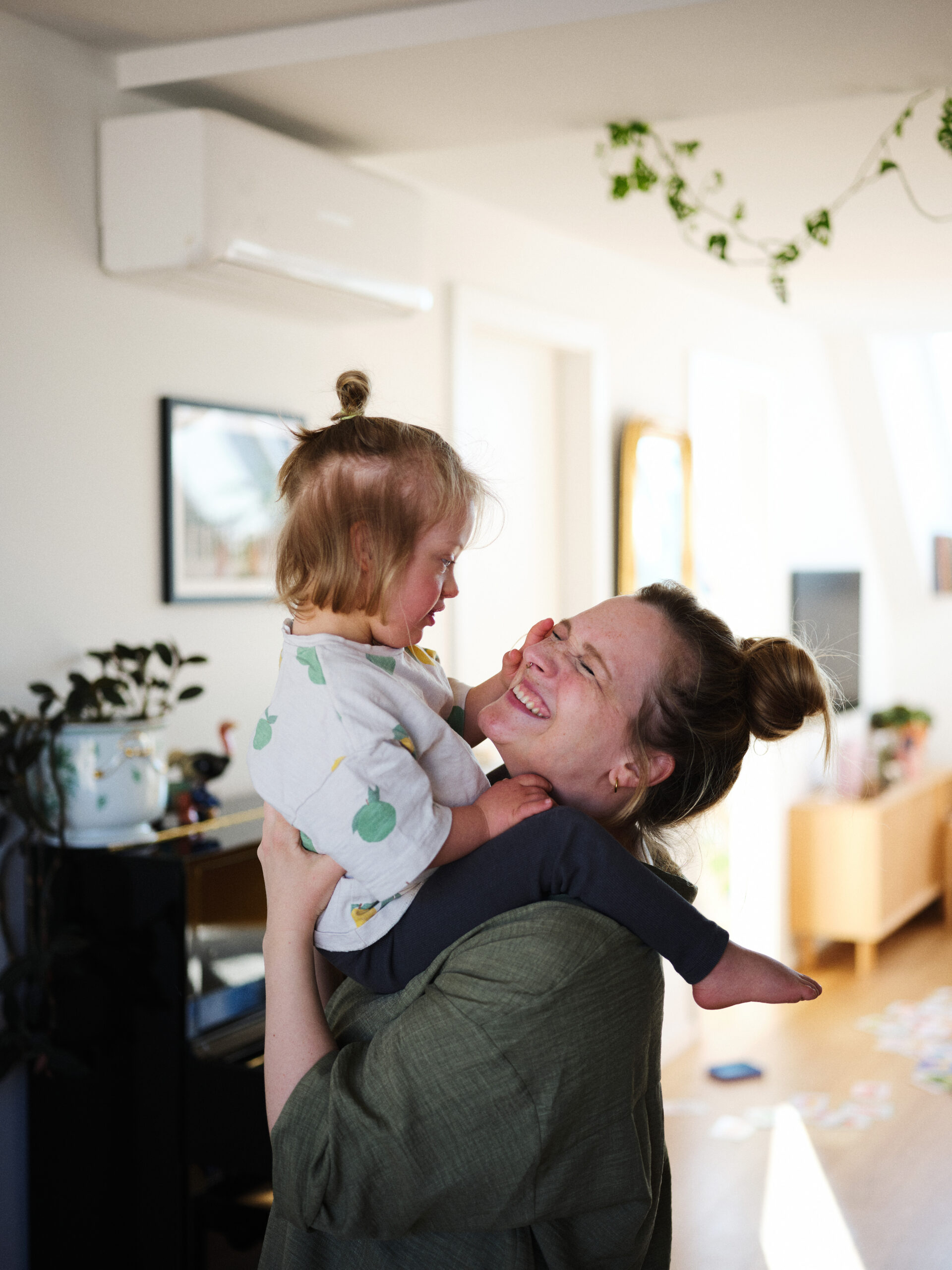 Valerie hält ihren Sohn Emil in den Armen. Sie lacht und Emil berührt ihr Gesicht.
