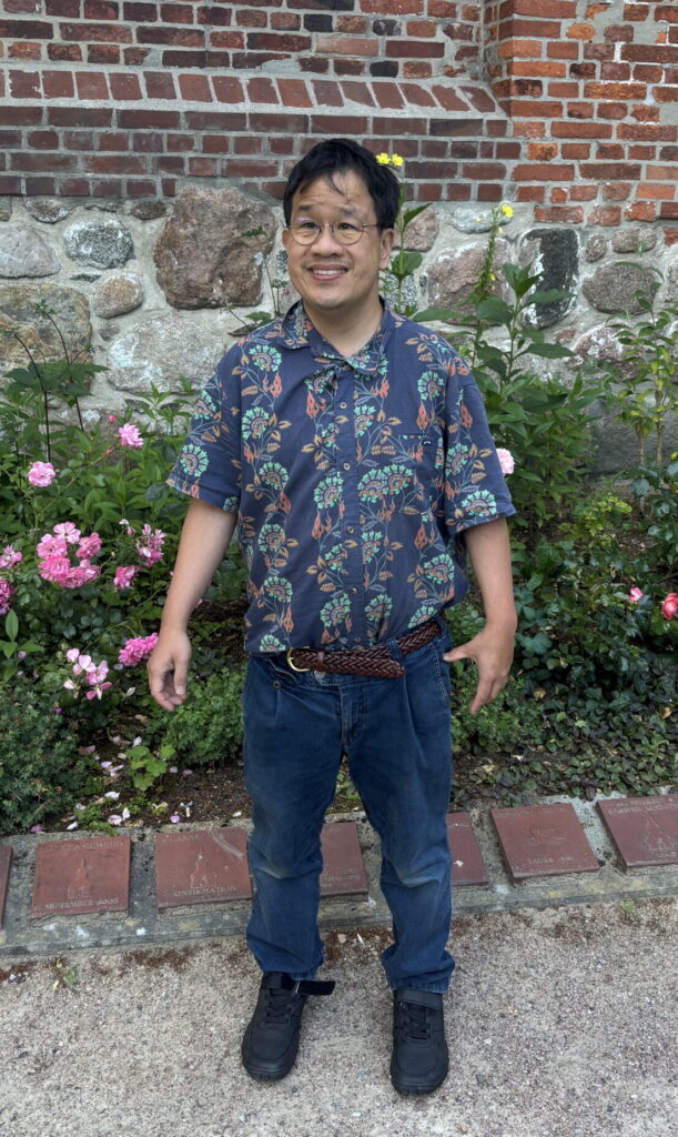 Das Foto zeigt Ing Han Ong. Er schaut mit freundlichen Blick nach links. Er hat kurze schwarze Haare und eine Brille.