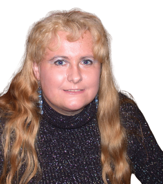 Eine Frau mit blonden langen Haaren schaut mit freundlichen Blick in die Kamera.