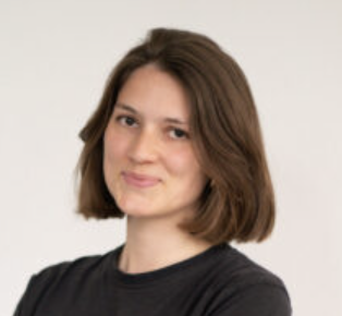 Christina Kobl schaut mit freundlichen Blick in die Kamera. Sie hat braune Haare und trägt ein schwarzes T-Shirt.